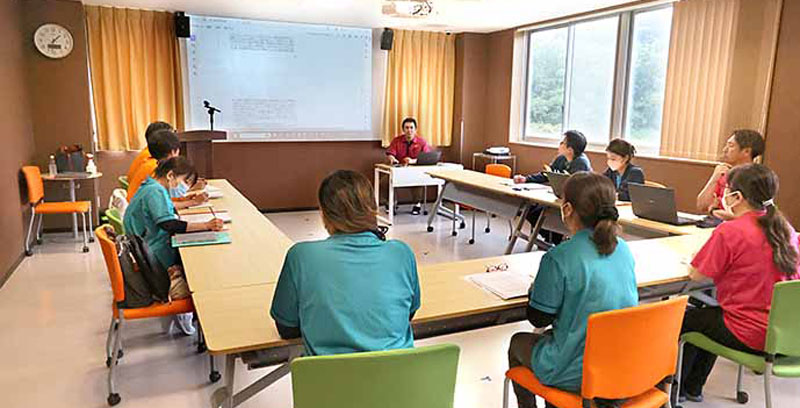 講師が教室で受講者に研修を行っている様子